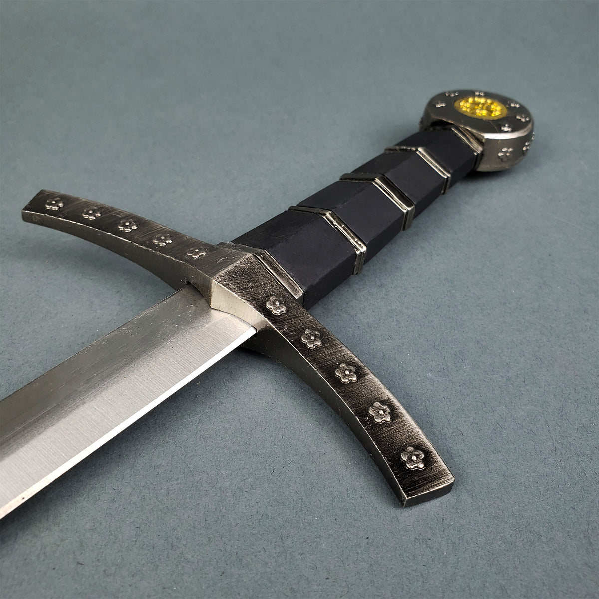 Close up of Knights Templar sword for sale showing steel crossguard with rosette studs and black wrapped grip