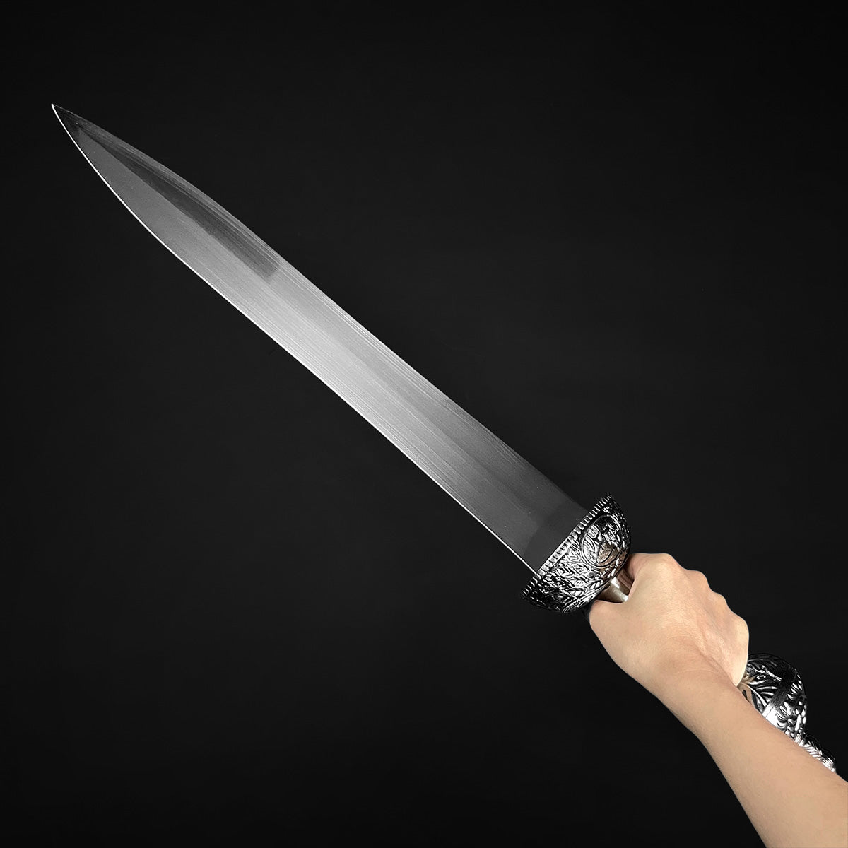 Roman Gladius Medieval Sword hand held ornate hilt polished steel blade on black background Knights Collection