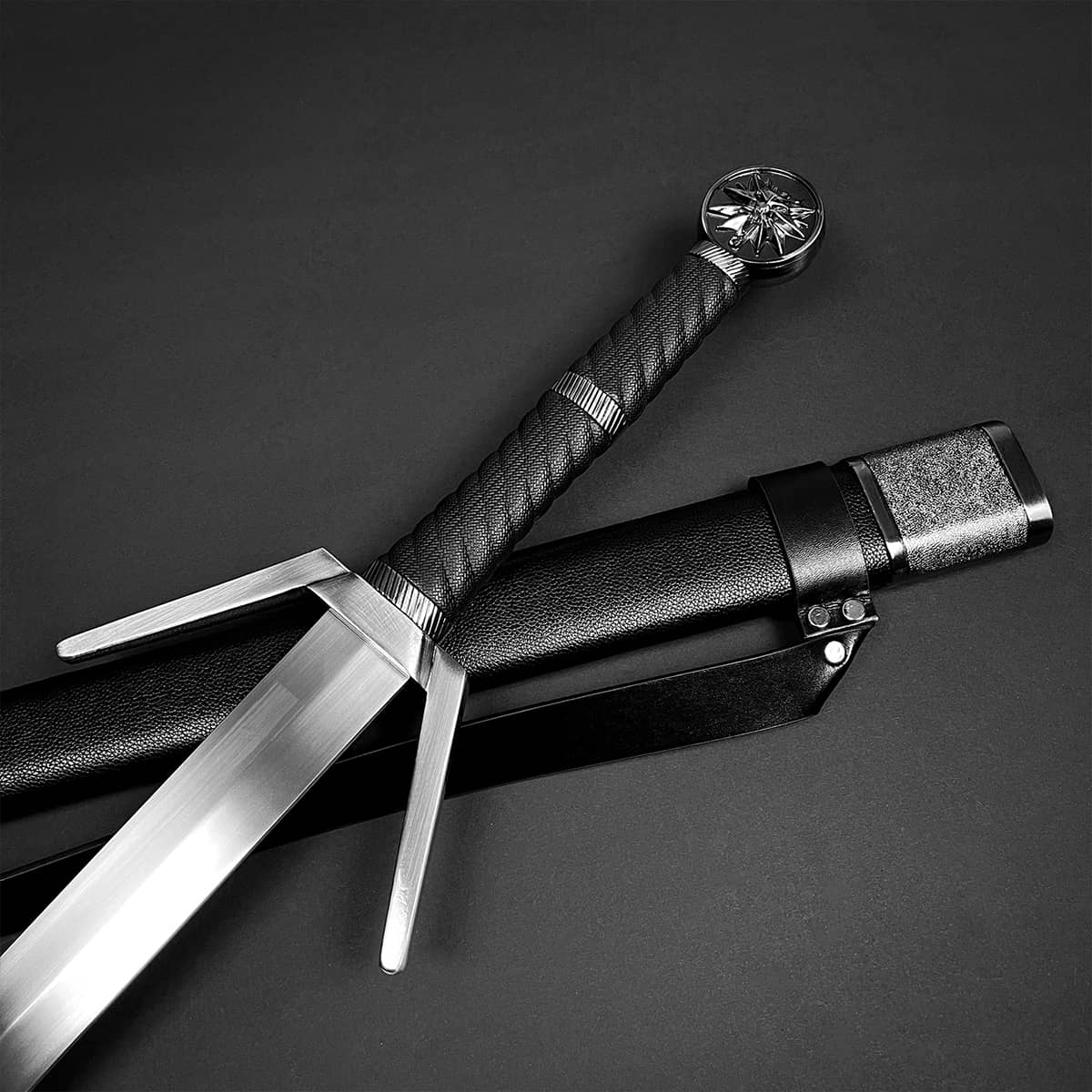 Knight's Collection collector medieval sword replica with detailed hilt and black scabbard on dark background