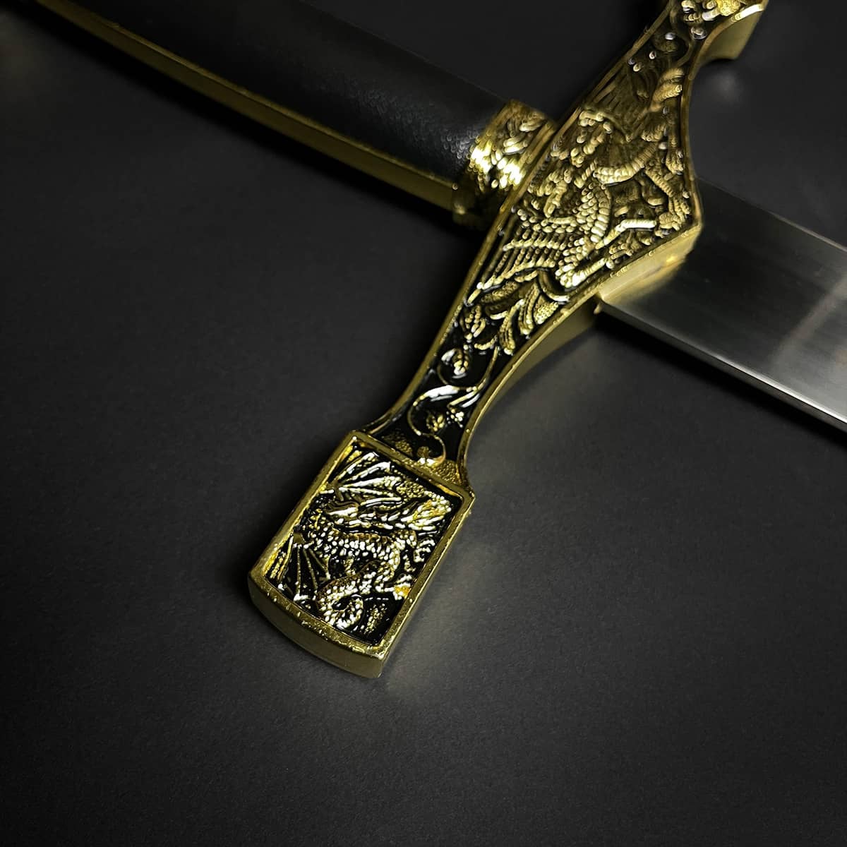 Close-up of decorative Excalibur Medieval sword handle with intricate gold dragon engravings by Knight Collections