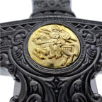 Close-up of decorative Knights Templar medieval sword hilt with detailed black and gold design