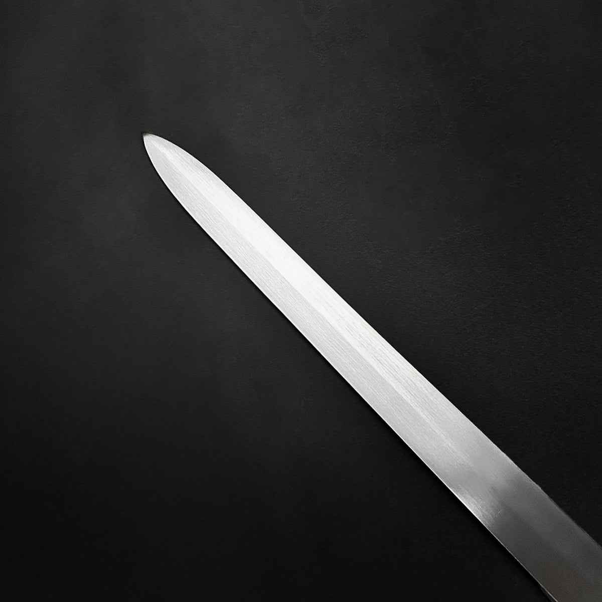 Sharp blade of a hand-forged medieval sword from Knight's Collection on black background