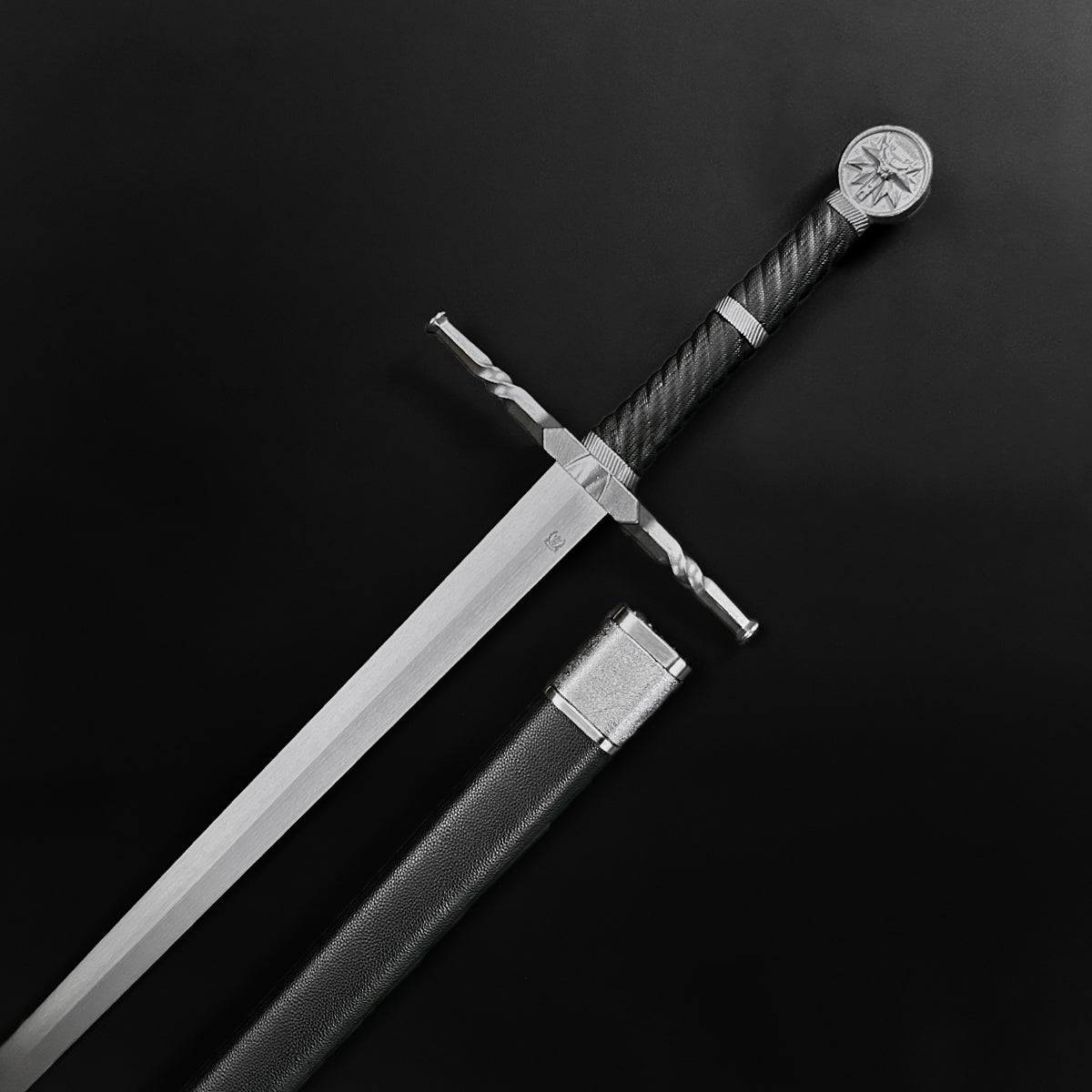 Knight's Collection hand-forged medieval sword with detailed crossguard and black leather sheath on black background