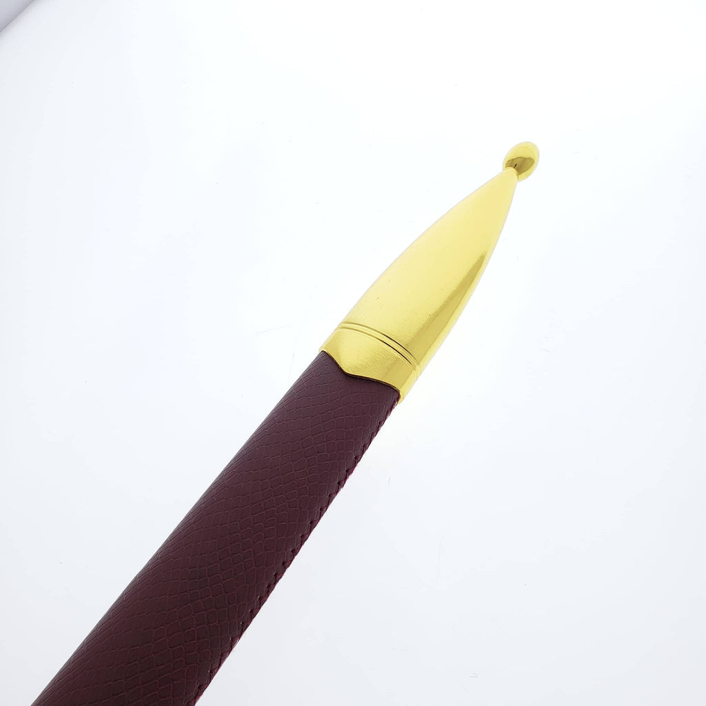 Close-up of medieval one hand sword sheath tip with gold-colored metal cap and brown textured leather