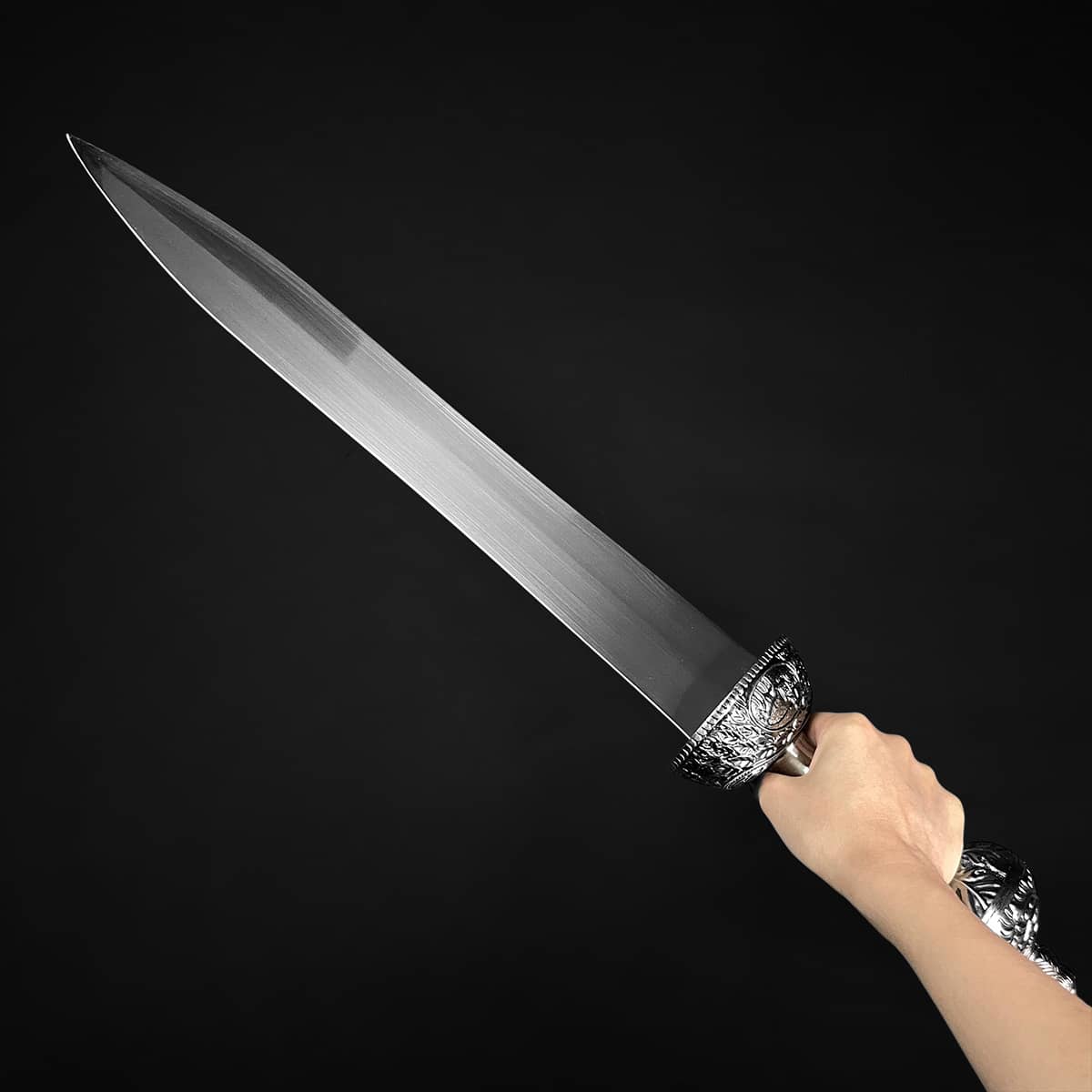 Roman Gladius Medieval Sword hand held ornate hilt polished steel blade on black background Knights Collection