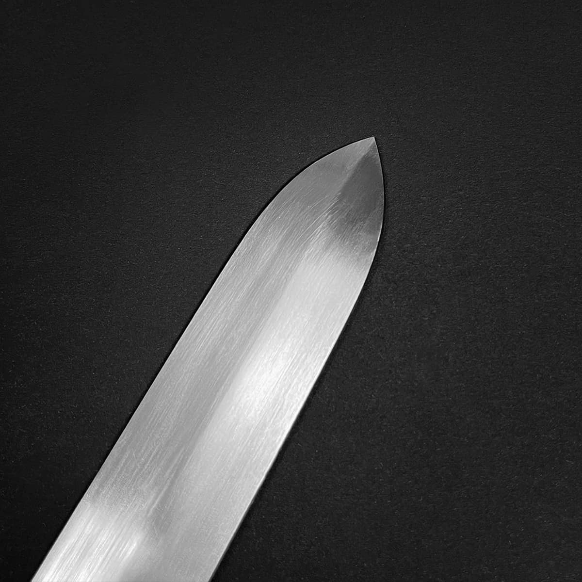 Close-up of a shiny blade tip from a medieval sword for sale by Knight's Collection on black background